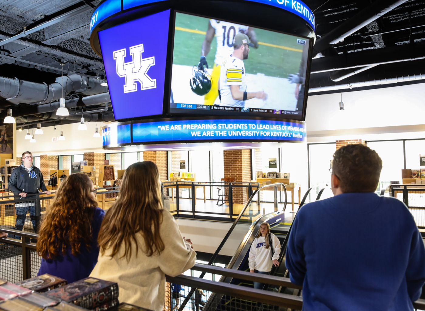 students watching Rugby match on the screen inside store