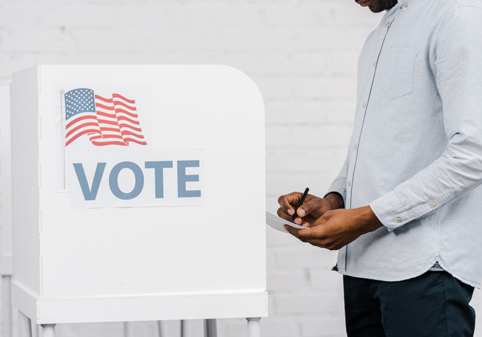 Student casting ballot at voting booth